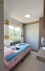 a bedroom with a bed and a window at Apto Antúrios|3Q. Sacada c/Churrasqueira in Piratuba
