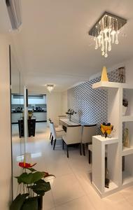 a dining room and living room with a table and chairs at Apto Antúrios|3Q. Sacada c/Churrasqueira in Piratuba