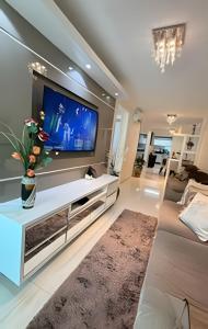 a living room with a large flat screen tv at Apto Antúrios|3Q. Sacada c/Churrasqueira in Piratuba