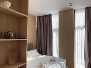 a bedroom with a bed and a window with towels at Elite Sunset Residence in Vlorë