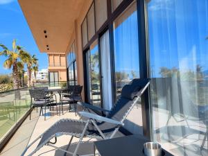 a balcony with a chair and a table and some windows at Elite Sunset Residence in Vlorë