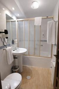 a bathroom with a toilet and a sink and a shower at Hostal Anosa Casa in Santiago de Compostela