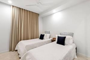 two beds in a hotel room with curtains at THE COSMOPOLITAN COTTON TREE Unit 10207 Cotton Tree in Maroochydore +16 photos