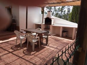 a patio with a table and chairs and a stove at Palacete Dos Alcaides in Minas de São Domingos