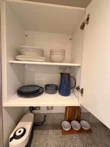 a cupboard with plates and bowls and other dishes at VIP apartment paddington in London +36 photos