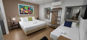 a small room with two beds and a couch at Cais 75 Studios & Suites in Aveiro
