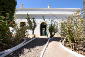 a white building with a green door in a yard at Palacete Dos Alcaides in Minas de São Domingos