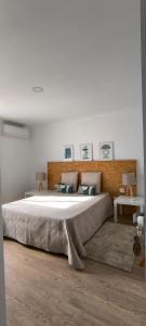 a large bed in a white room with two tables at Upstairs Home in Ponta Delgada