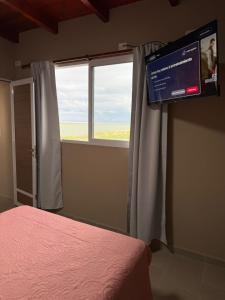 a bedroom with a bed and a tv and a window at Don Isidro in Miramar +19 photos