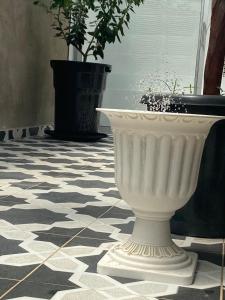 a large white vase sitting on a tile floor at Magic Garden Luxury Pent-house in Bello