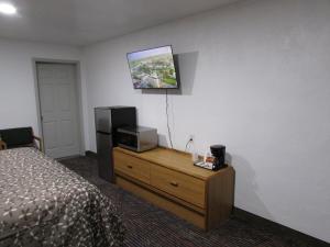 a hotel room with a bed and a tv on the wall at Parsons Inn Downtown Parsons,Tn in Parsons
