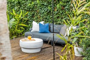 a garden with a couch with pillows and a table at Eastside Oasis - Heart of Norwood with Poolside Garden in Norwood