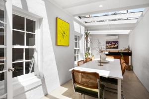 a dining room with a white table and chairs at Eastside Oasis - Heart of Norwood with Poolside Garden in Norwood +36 photos