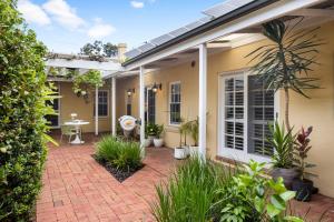 a house with a brick patio with plants at Eastside Oasis - Heart of Norwood with Poolside Garden in Norwood