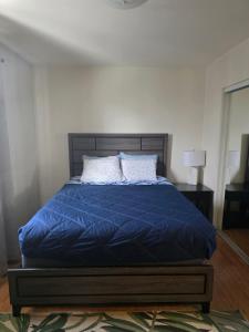 a bed with a blue comforter and two pillows at RJN in Fairbanks