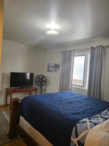 a bedroom with a bed and a television and a window at RJN in Fairbanks