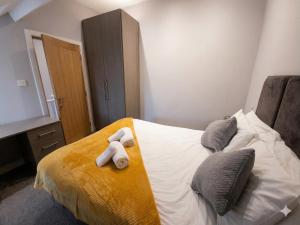 a bedroom with a bed with towels on it at Central 3 beds with parking in Reading