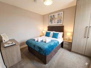a bedroom with a bed with blue and white pillows at Central 3 beds with parking in Reading