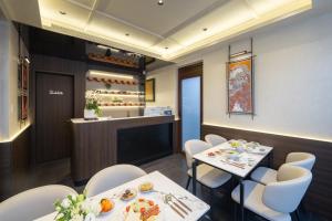 a restaurant with white tables and chairs and a counter at Liuli Tile Courtyard Hotel Houhai Tian Anmen Wangfujing in Beijing +21 photos