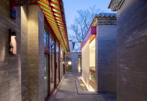 an alleyway between two buildings with lights on at Liuli Tile Courtyard Hotel Houhai Tian Anmen Wangfujing in Beijing