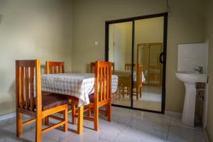 a dining room with a table and chairs and a sink at Timba Lodge in Blantyre
