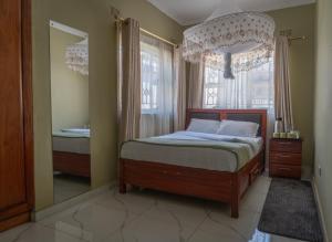 a bedroom with a bed and a large mirror at Timba Lodge in Blantyre