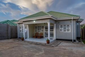 a small house with a porch with two chairs at Timba Lodge in Blantyre +7 photos