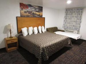 a hotel room with a bed with white pillows at Parsons Inn Downtown Parsons,Tn in Parsons