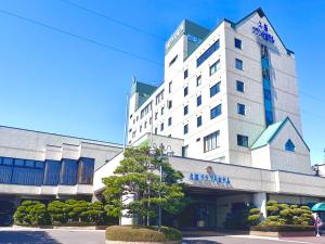 a large white building with a sign on it at Kuji Grand Hotel in Kuji