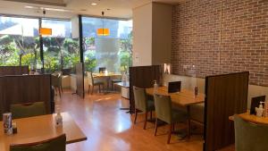 a restaurant with tables and chairs and a brick wall at Kuji Grand Hotel in Kuji