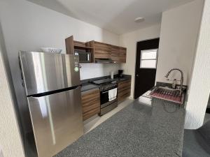 a kitchen with a stainless steel refrigerator and a stove at Comfortable 2BR Condo pool & gym in Tulum +9 photos