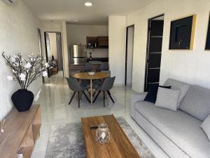 a living room with a couch and a table at Comfortable 2BR Condo pool & gym in Tulum