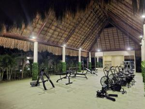 a gym with a bunch of exercise bikes in a building at Comfortable 2BR Condo pool & gym in Tulum