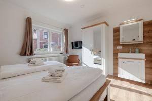 a hotel room with two beds and a window at Ankerplatz Sylt in Sylt