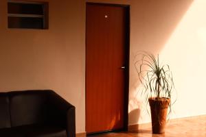 a wooden door with a potted plant in front of it at Pousada - Árvore da Vida in Bonito