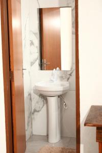 a bathroom with a white sink and a mirror at Pousada - Árvore da Vida in Bonito