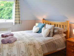 a bedroom with a bed with two pillows on it at Glenlivet View in Auchnastank