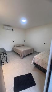 a bedroom with two beds and a rug on the floor at Casa do Lago Serra da Mesa - Niquelandia in Niquelândia