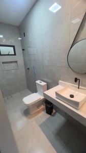 a bathroom with a toilet and a sink and a mirror at Casa do Lago Serra da Mesa - Niquelandia in Niquelândia +6 photos