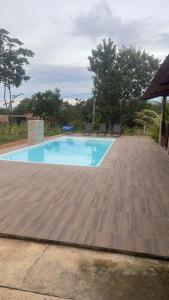 a large swimming pool with a wooden floor and chairs at Casa do Lago Serra da Mesa - Niquelandia in Niquelândia