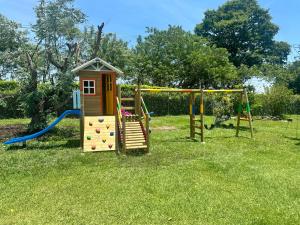 a playground with a slide and a swing set at Finca Villa AlCon - Hostel in Pereira