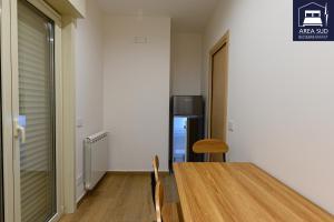 ein Esszimmer mit einem Tisch und einem Kühlschrank in der Unterkunft Area Sud in Canicattì + 22 Fotos