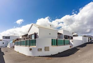 a white building with green gates on a street at Luxury House Sofie in Tías