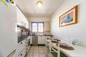 a kitchen with white cabinets and a table with chairs at Luxury House Sofie in Tías