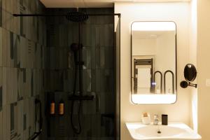 a bathroom with a shower and a sink and a mirror at Blume Cruz Suites in Madrid +83 photos