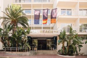 a hotel entrance with palm trees in front of it at BLUESEA Coral Beach in Es Cana