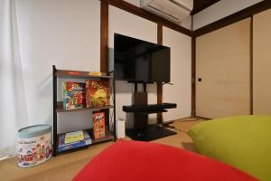 a living room with a flat screen tv on a wall at The Nomad Inn Yugejima in Kami-yuge