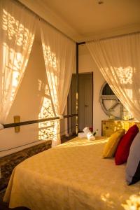 a bedroom with a bed with curtains and a window at La Casica del Abuelo Valentín in Torreblascopedro