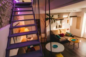 a purple spiral staircase in a living room with a couch at La Casica del Abuelo Valentín in Torreblascopedro