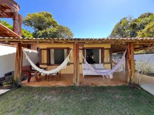 a house with two hammocks on a patio at Casa Cris in Itaúnas